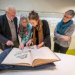 Jan Lindenbergh and his daughter look through Merian’s book with WUR president Louise Fresco. On the right, curator Liesbeth Missel of the WUR Library.