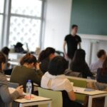 Studenten in de collegezaal met op de achtergrond de leraar