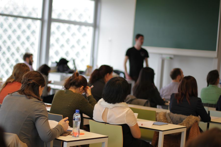 Studenten in de collegezaal met op de achtergrond de leraar