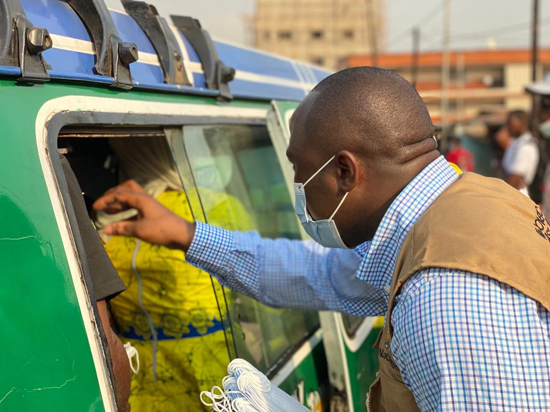 Man deelt mondkapjes uit in Sierra Leona