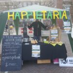 Happietariakraam op de markt in Wageningen boxen te verkopen.