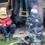 Twee kinderen houden worstje boven vuur