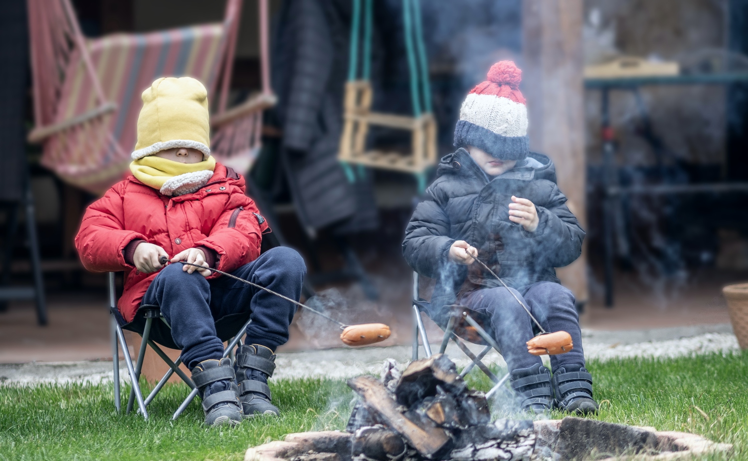 Twee kinderen houden worstje boven vuur