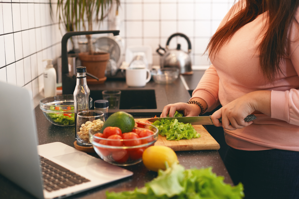 Vrouw met overwicht staat te koken
