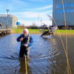 Marten Scheffer in de vijver bij zijn kunstwerk 'must leave'.