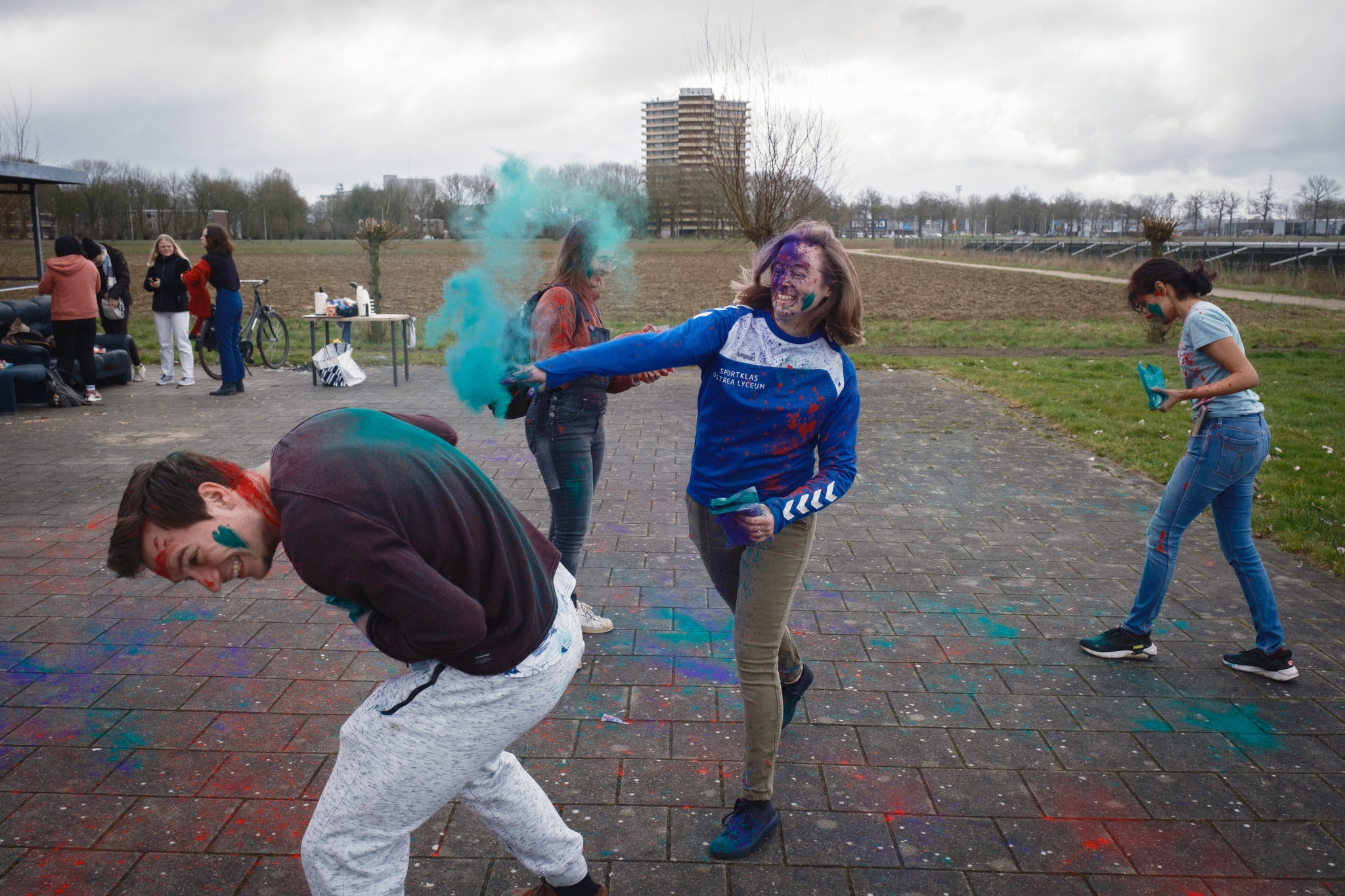 Vrouw gooit met blauw verfpoeder.