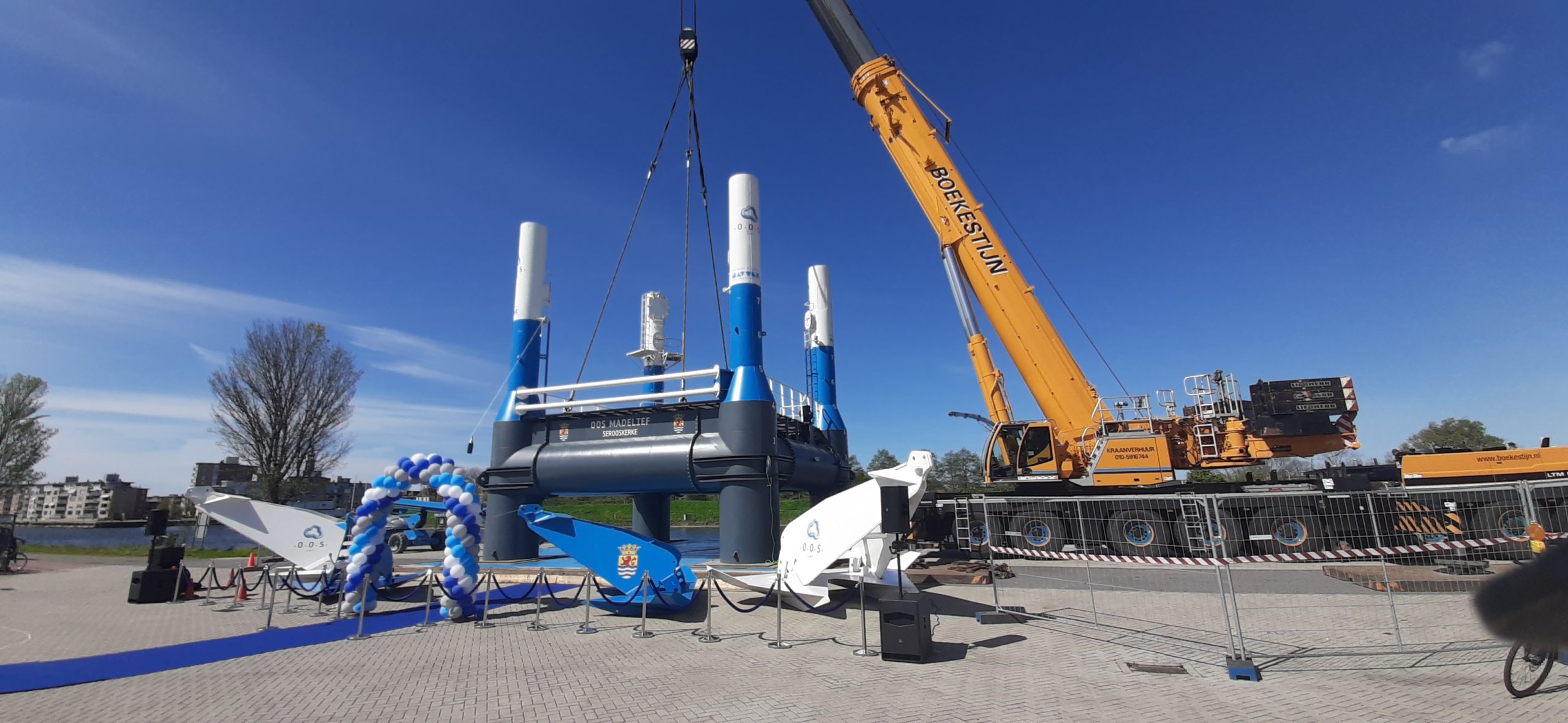 Een kraan laat een mini-versie van de mosselfarm-constructie te water.