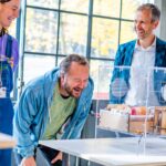 Gert Jan Veldwisch naast bezoekers die het op de DDW 2024 de project-expo bekijken van TU/e-student Taissia Visser: een materiaalstudie op basis van SCOBY's (waarmee ook kombucha wordt gemaakt).