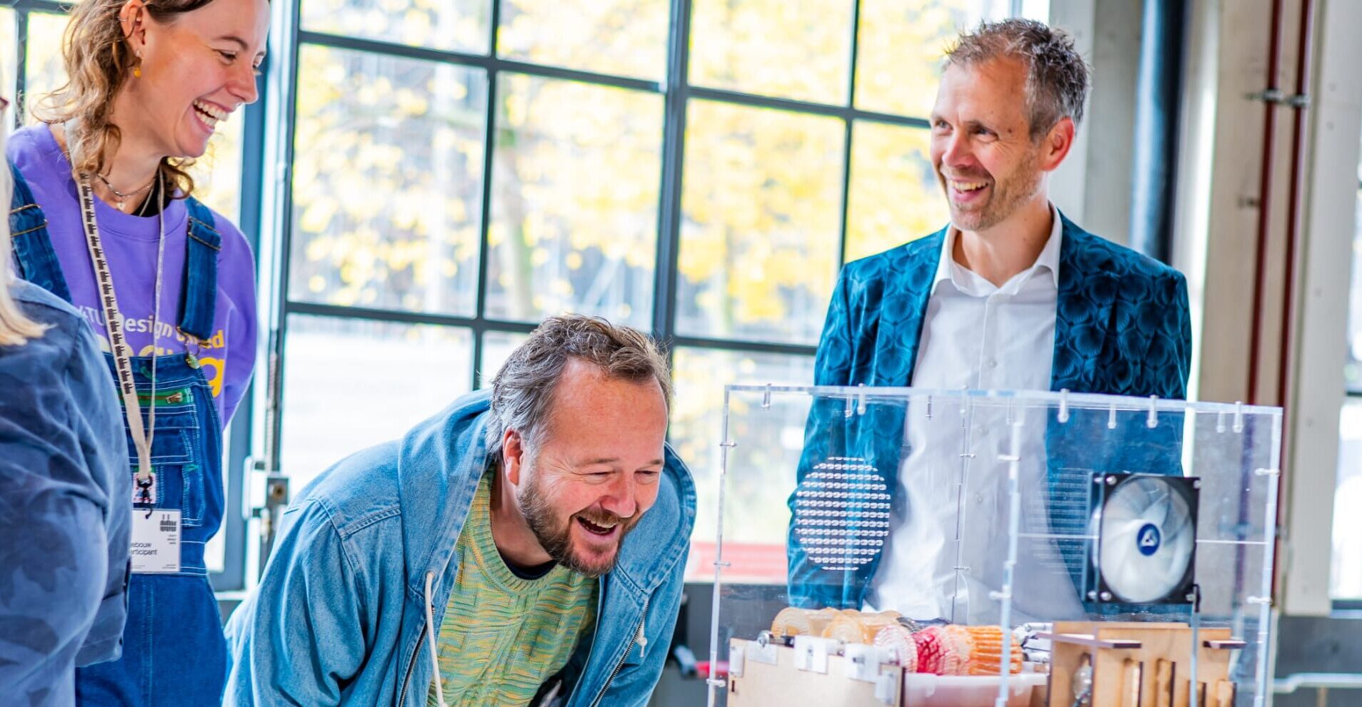 Gert Jan Veldwisch naast bezoekers die het op de DDW 2024 de project-expo bekijken van TU/e-student Taissia Visser: een materiaalstudie op basis van SCOBY's (waarmee ook kombucha wordt gemaakt).